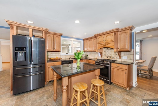 kitchen with a kitchen island, a breakfast bar, dark stone countertops, decorative backsplash, and stainless steel appliances