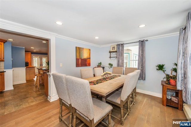 dining space with light hardwood / wood-style flooring and ornamental molding