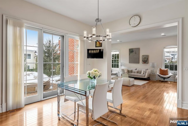 dining room with an inviting chandelier and light hardwood / wood-style flooring