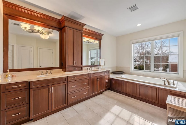 bathroom with tile patterned flooring, vanity, and a tub to relax in