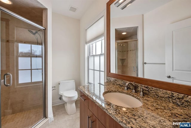 bathroom with vanity, a shower with shower door, and toilet