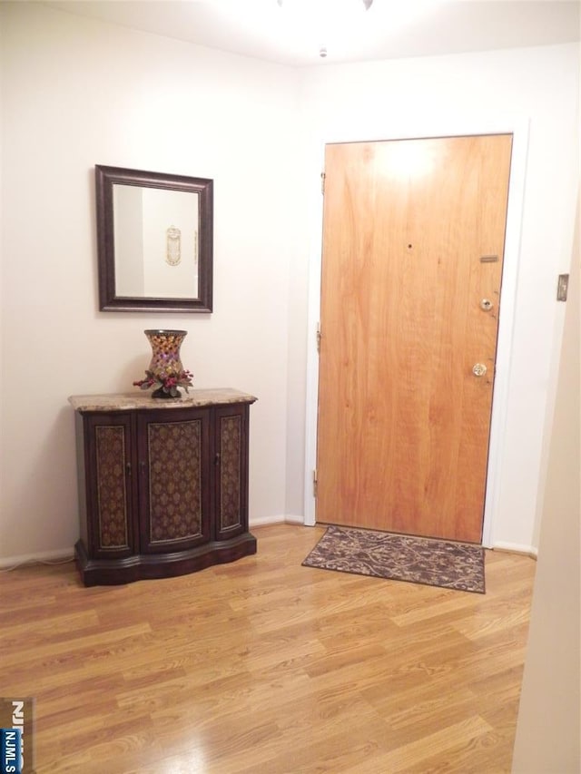 entryway with light wood finished floors and baseboards