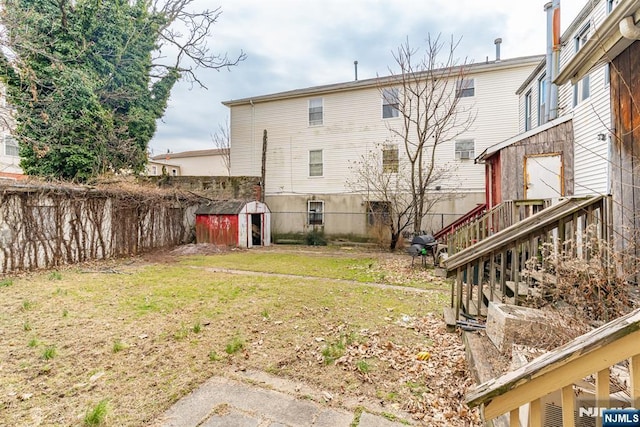 rear view of property featuring a lawn and a shed