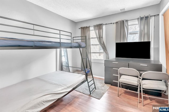 bedroom featuring hardwood / wood-style floors and a textured ceiling