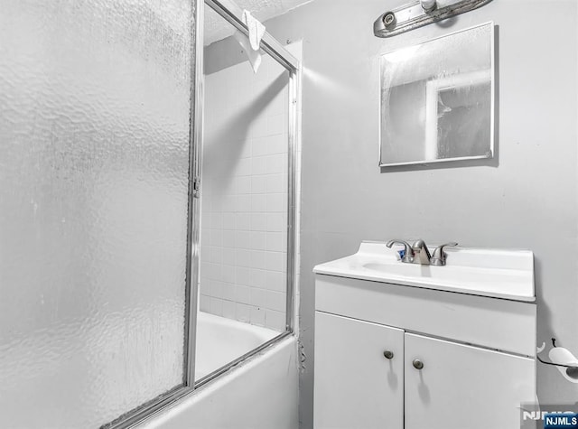 bathroom featuring vanity and enclosed tub / shower combo