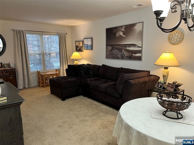 carpeted living room featuring a notable chandelier