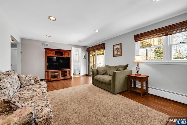 living room with dark wood-type flooring and baseboard heating