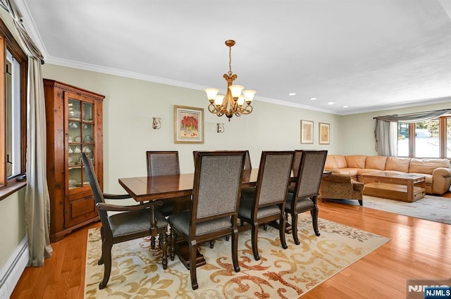 dining room with light hardwood / wood-style flooring, ornamental molding, a chandelier, and baseboard heating