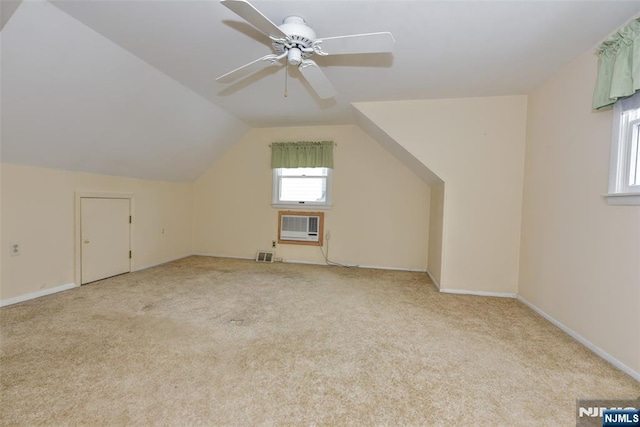 bonus room with a wall unit AC, light colored carpet, ceiling fan, and vaulted ceiling