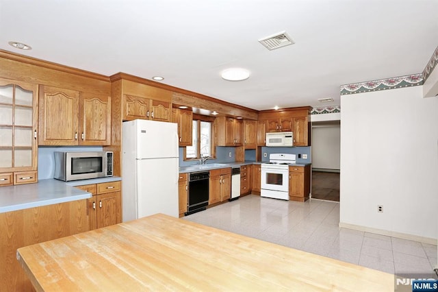 kitchen with sink, light tile patterned floors, white appliances, and kitchen peninsula