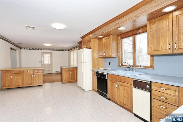 kitchen featuring sink, a wealth of natural light, black dishwasher, and white refrigerator