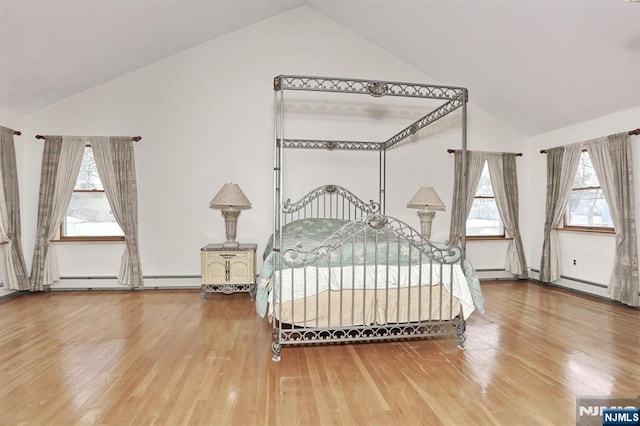 bedroom featuring wood-type flooring, a baseboard heating unit, and high vaulted ceiling