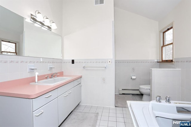 bathroom featuring a baseboard radiator, tile walls, vanity, toilet, and tile patterned floors