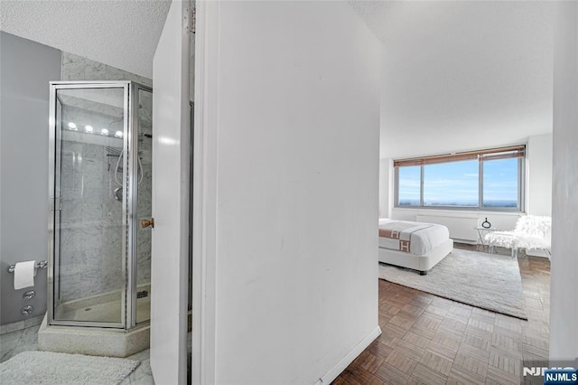 bathroom with a textured ceiling and a stall shower