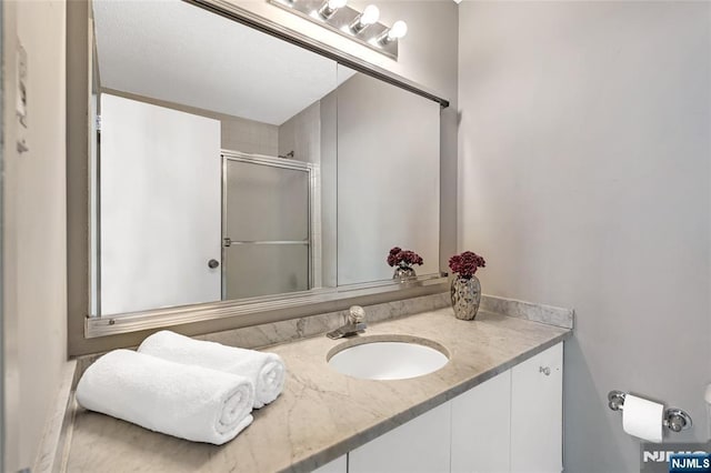 bathroom featuring an enclosed shower and vanity