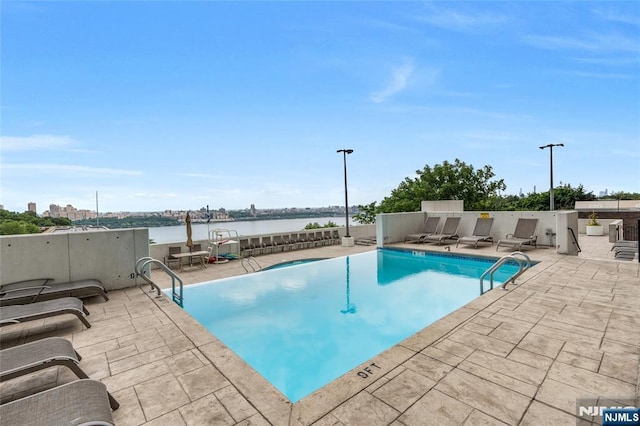 pool with a patio and a water view