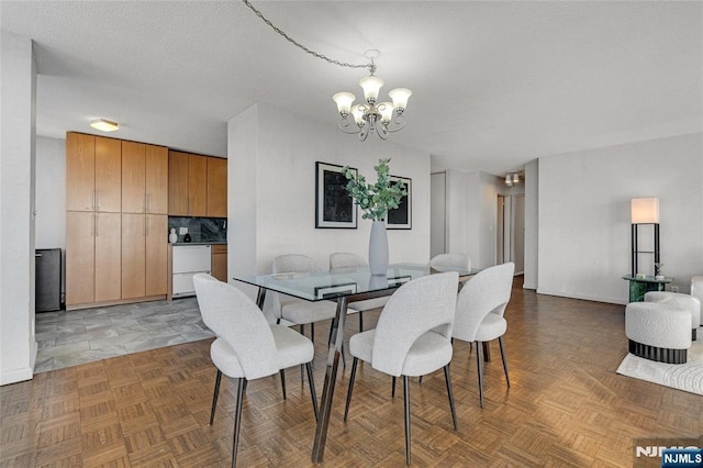 dining room featuring a textured ceiling and an inviting chandelier