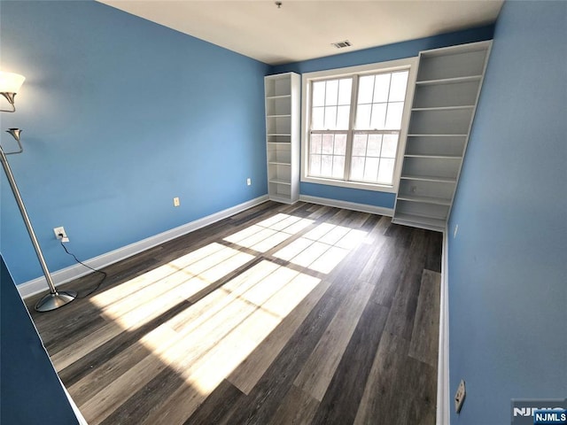 spare room with dark wood-type flooring