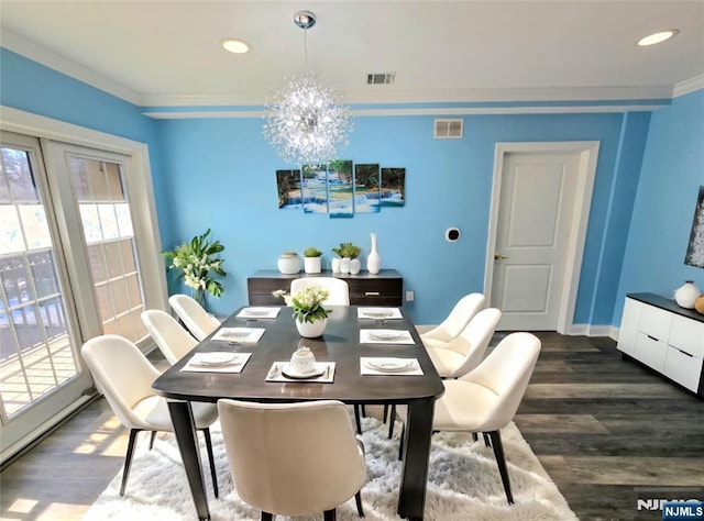 dining room featuring dark hardwood / wood-style flooring, crown molding, and an inviting chandelier