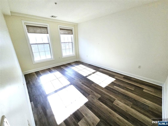 empty room with dark hardwood / wood-style flooring