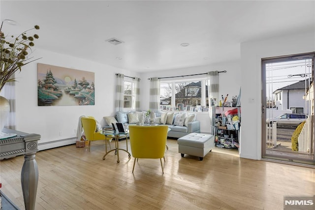 living room with a baseboard radiator and light hardwood / wood-style flooring