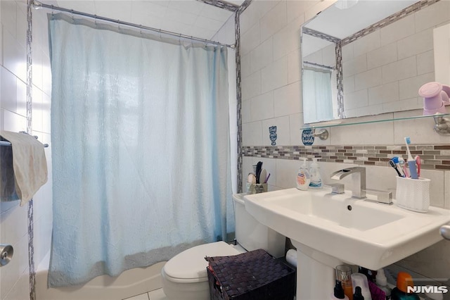 full bathroom featuring tasteful backsplash, sink, tile walls, toilet, and shower / bath combo with shower curtain