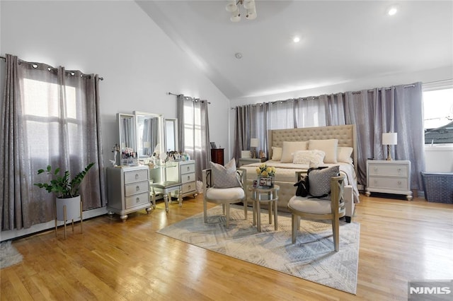 bedroom with high vaulted ceiling and light hardwood / wood-style floors