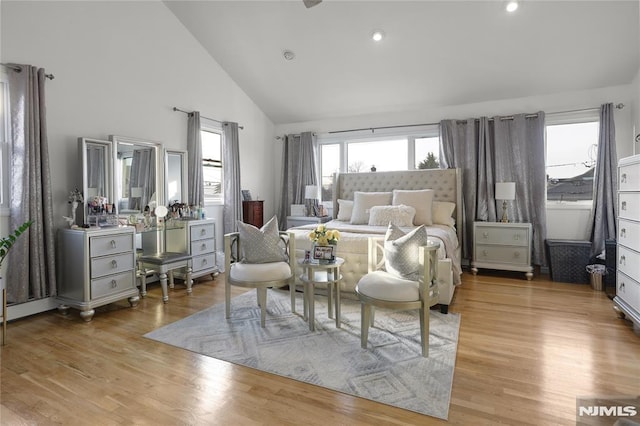 bedroom featuring high vaulted ceiling and light hardwood / wood-style flooring