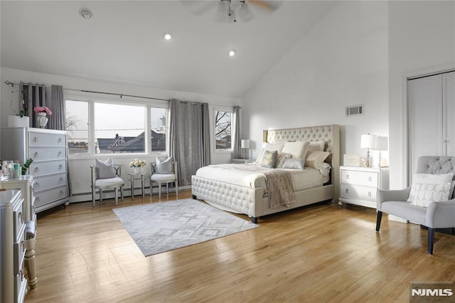 bedroom with ceiling fan, a baseboard radiator, high vaulted ceiling, and light wood-type flooring