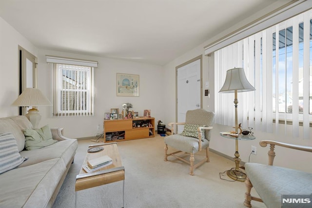 carpeted living room featuring baseboards