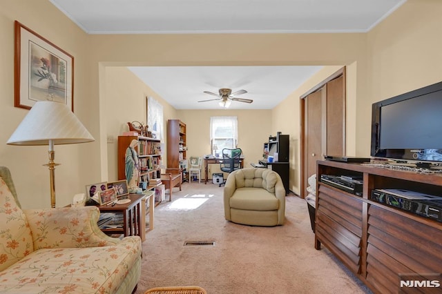 living room featuring ceiling fan, visible vents, and light carpet