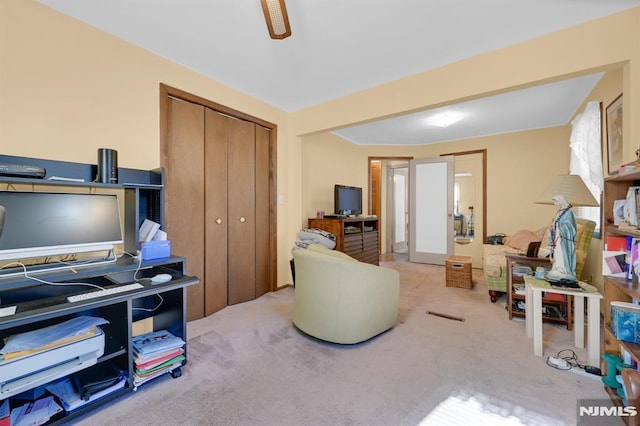 carpeted office space featuring ceiling fan