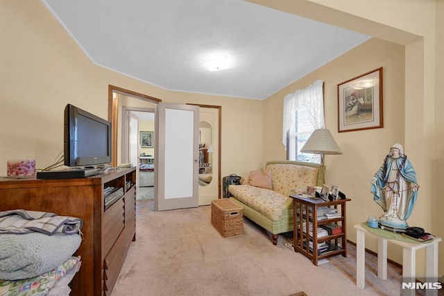 living area featuring french doors and light carpet