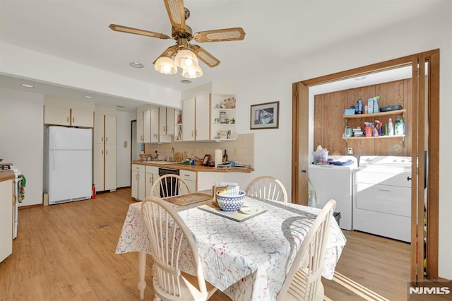 dining room featuring a ceiling fan, separate washer and dryer, and light wood-type flooring