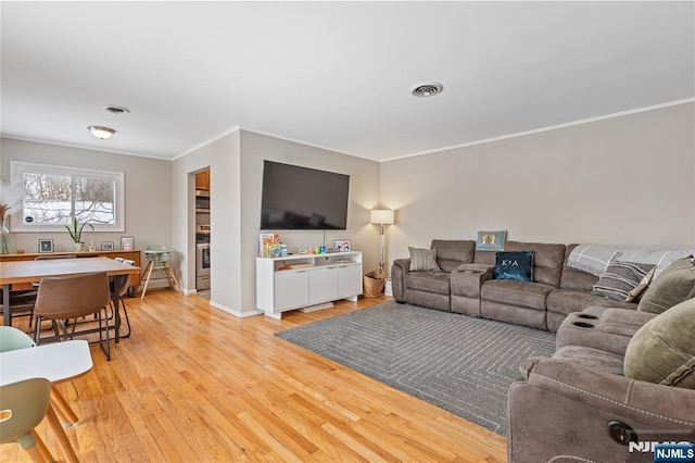 living room with crown molding and light wood-type flooring