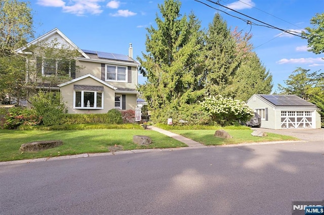 view of front of home with a garage, an outdoor structure, a front lawn, and solar panels