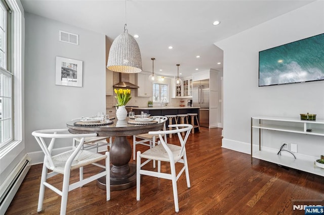 dining room with baseboard heating, sink, and dark hardwood / wood-style flooring