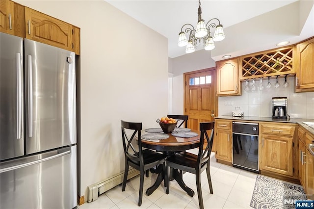 kitchen featuring light tile patterned flooring, an inviting chandelier, decorative light fixtures, stainless steel fridge, and backsplash