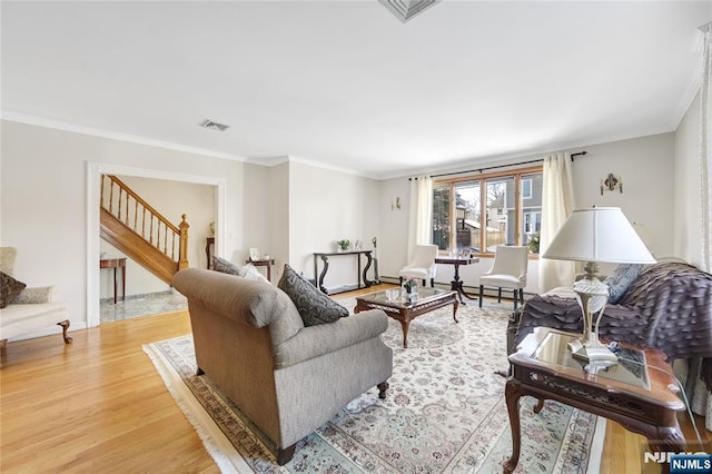 living room with crown molding and light hardwood / wood-style floors