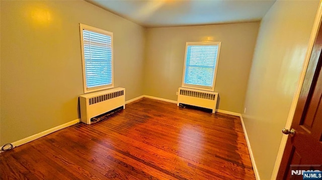 spare room with wood-type flooring and radiator