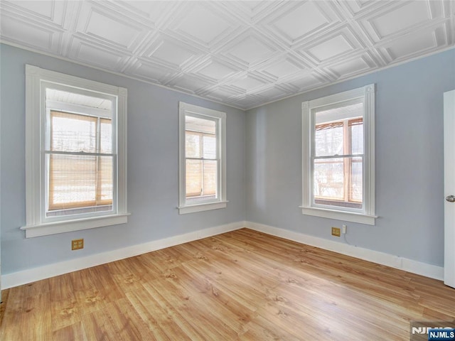 spare room featuring a wealth of natural light and light hardwood / wood-style floors