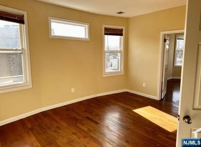 unfurnished room featuring dark wood-type flooring