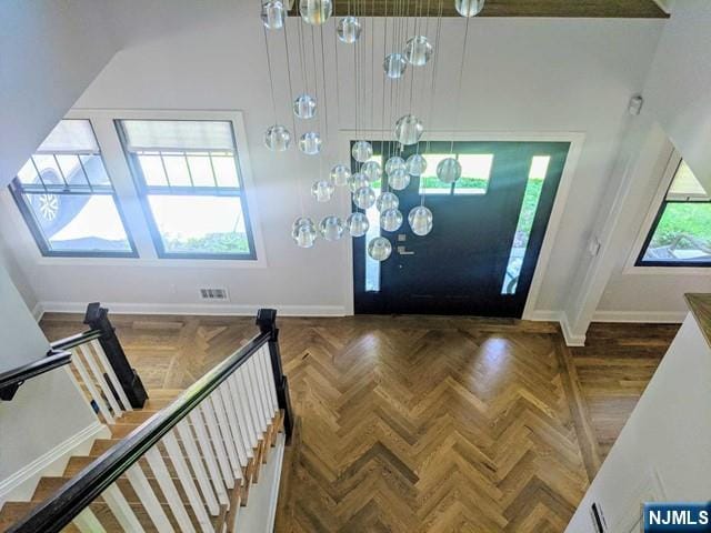 entrance foyer with stairway, visible vents, and baseboards