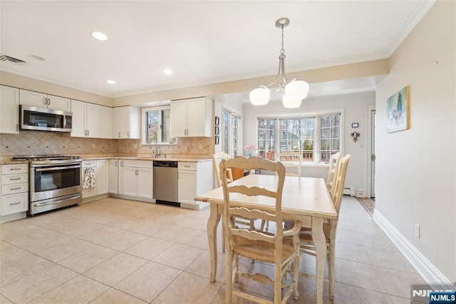 kitchen featuring visible vents, stainless steel appliances, crown molding, tasteful backsplash, and a chandelier