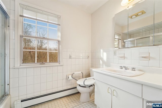 bathroom featuring vanity, a baseboard heating unit, tile walls, toilet, and tile patterned floors