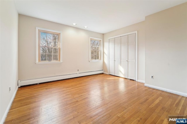 unfurnished bedroom with recessed lighting, baseboards, wood-type flooring, and baseboard heating