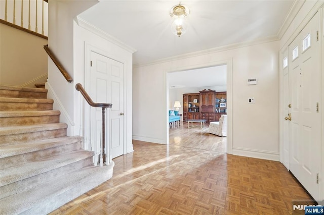 entryway with stairway, crown molding, and baseboards