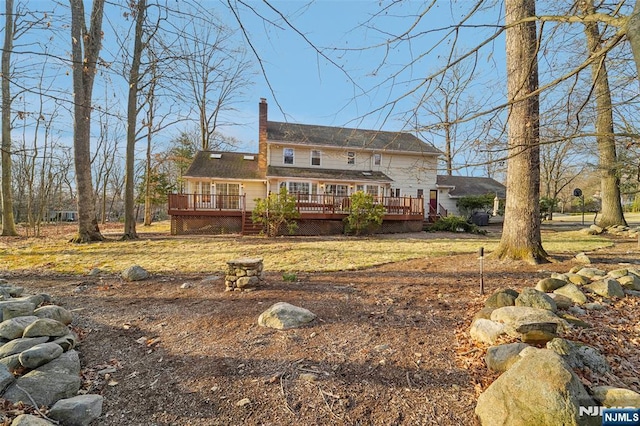 back of property with a wooden deck and a chimney