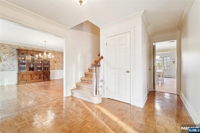 interior space with a notable chandelier, ornamental molding, and a wainscoted wall