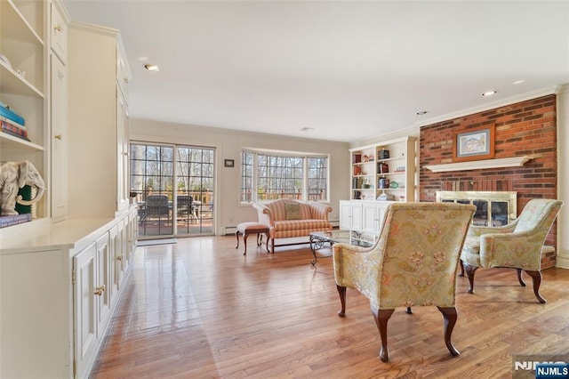 interior space with light wood-style flooring, recessed lighting, a fireplace, crown molding, and baseboard heating